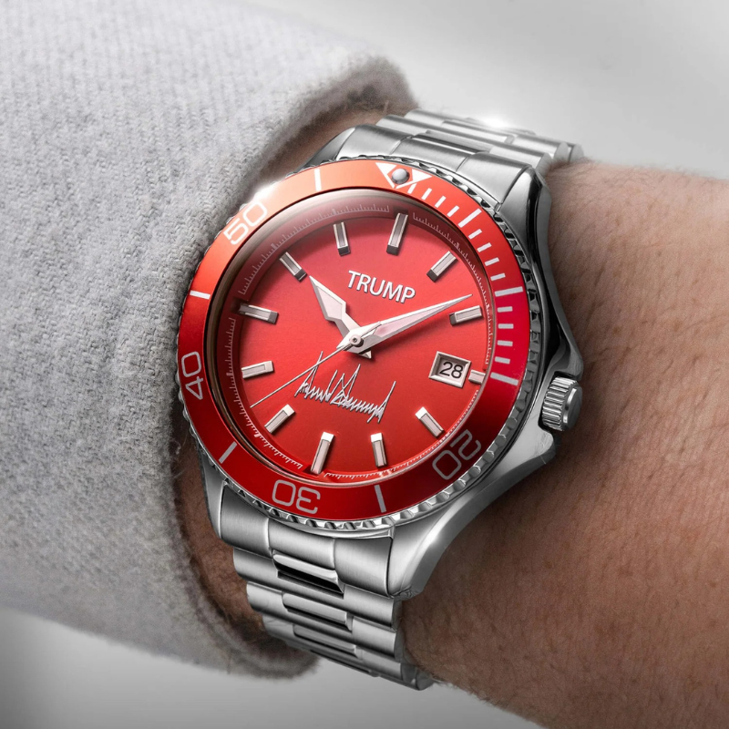 Trump red dial watch worn on wrist with gray sweater