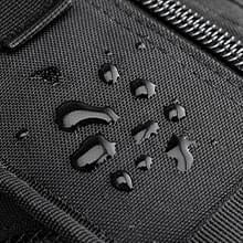 Close-up of water beading on the black tactical shoulder bag's fabric, showing water resistance