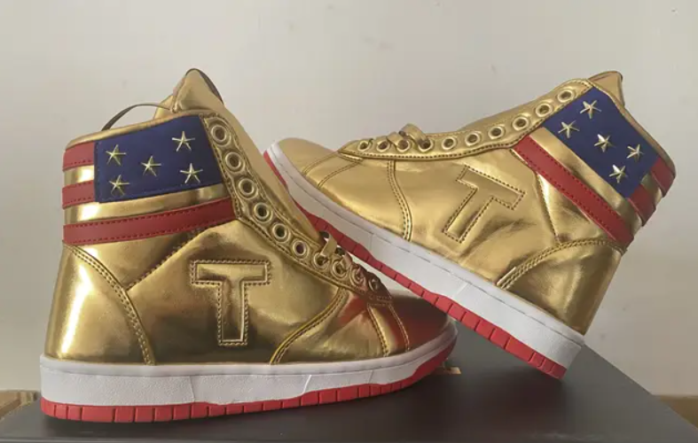 Gold Trump Never Surrender high-top sneakers, rear angled pair with flag design and T logo