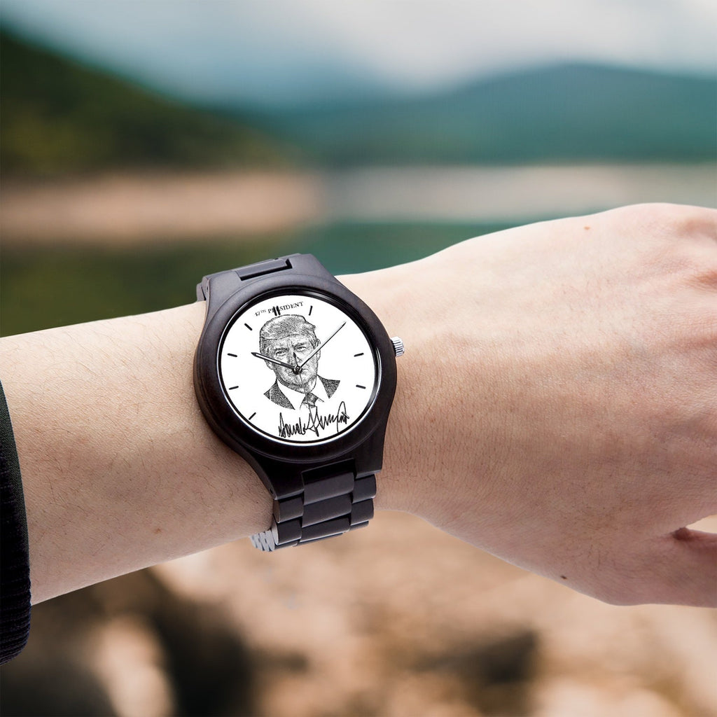 Victory Black Trump President 47 wooden watch worn on a wrist outdoors by a lake