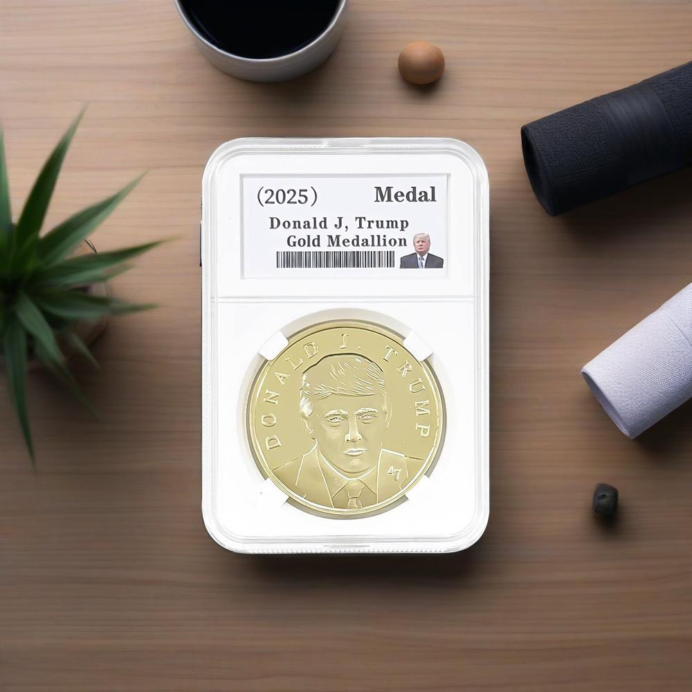 Donald J. Trump gold coin in graded slab case on wood desk with coffee