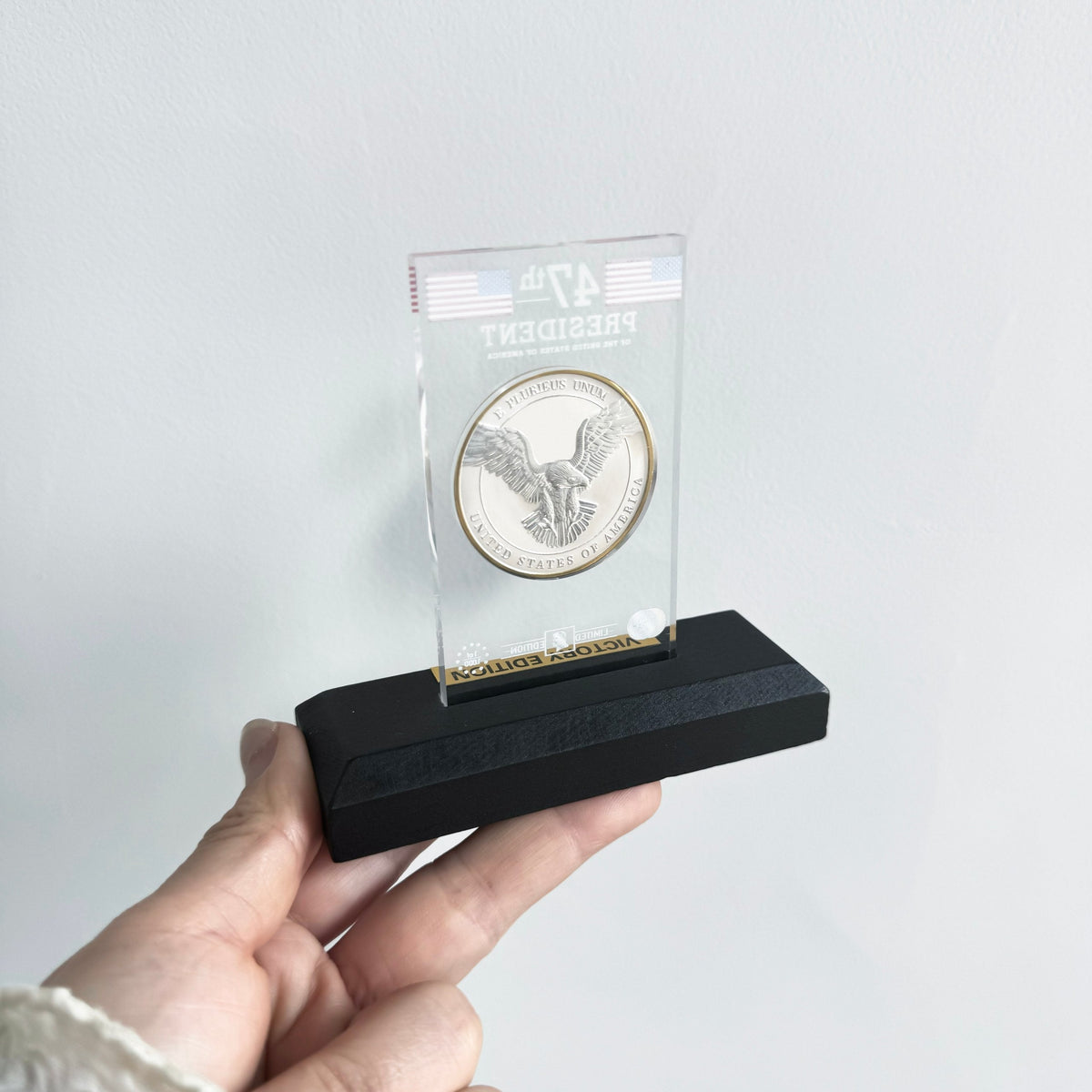 Victory coin eagle reverse in acrylic display stand held in hand
