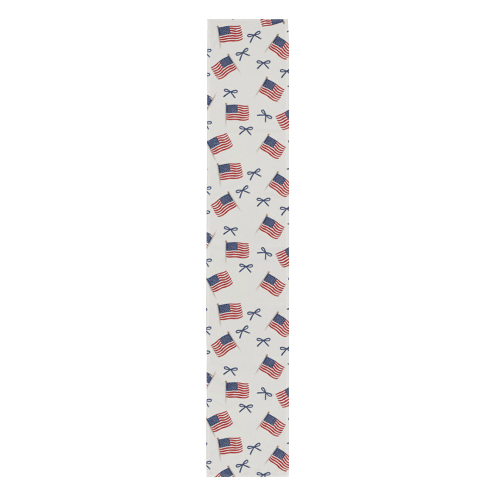 White table runner with repeating American flag and blue bow print